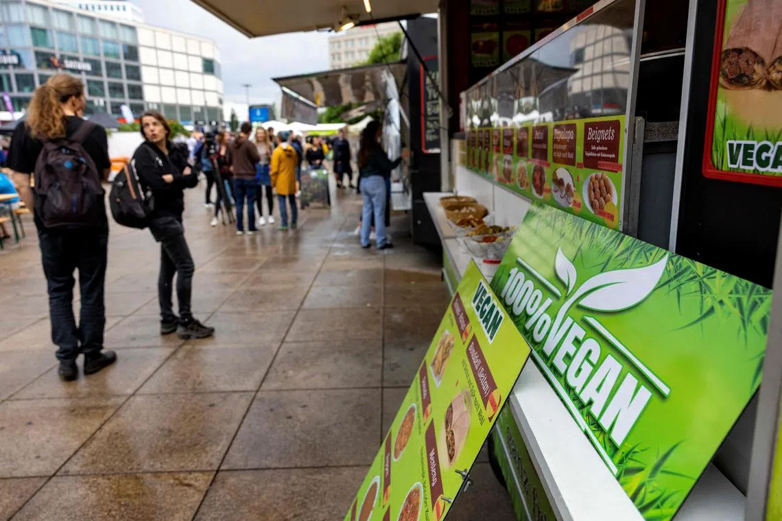 Visitors mill around vegan food stalls during the Vegan Summer Festival at Alexanderplatz square in Berlin on June 16, 2023. Despite being known for their love of sausages and schnitzel, Germans have been steadily eating less meat over the past few years. (Photo by Odd ANDERSEN / AFP)