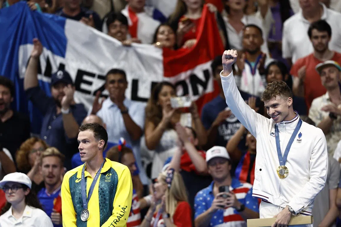 Paris 2024 Olympics - Swimming - Men's 200m Breaststroke Victory Ceremony - Paris La Defense Arena, Nanterre, France - July 31, 2024. Gold medallist Leon Marchand of France celebrates on the podium with silver medallist Zac Stubblety-Cook of Australia. REUTERS/Clodagh Kilcoyne