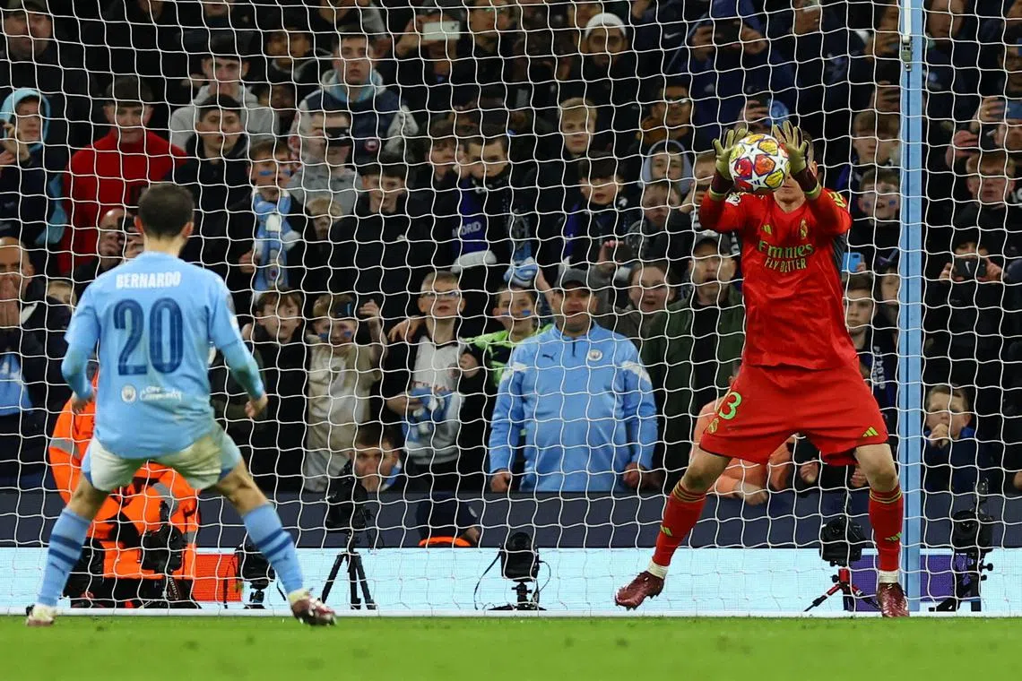 Soccer Football - Champions League - Quarter Final - Second Leg - Manchester City v Real Madrid - Etihad Stadium, Manchester, Britain - April 17, 2024 Real Madrid's Andriy Lunin saves a penalty taken by Manchester City's Bernardo Silva during the penalty shootout REUTERS/Molly Darlington     TPX IMAGES OF THE DAY