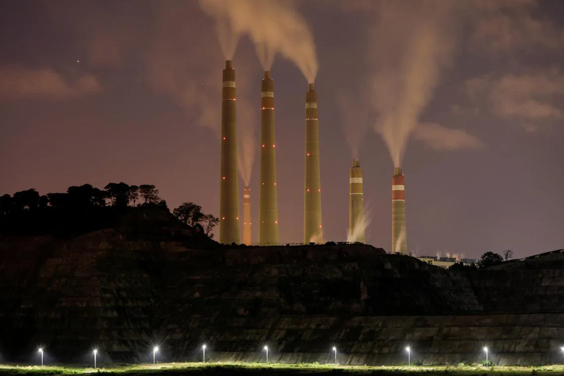 FILE PHOTO: Smoke and steam billows from the coal-fired power plant owned by Indonesia Power, next to an area for Java 9 and 10 Coal-Fired Steam Power Plant Project in Suralaya, Banten province, Indonesia, July 11, 2020. Picture taken July 11, 2020. REUTERS/Willy Kurniawan/File Photo/File Photo