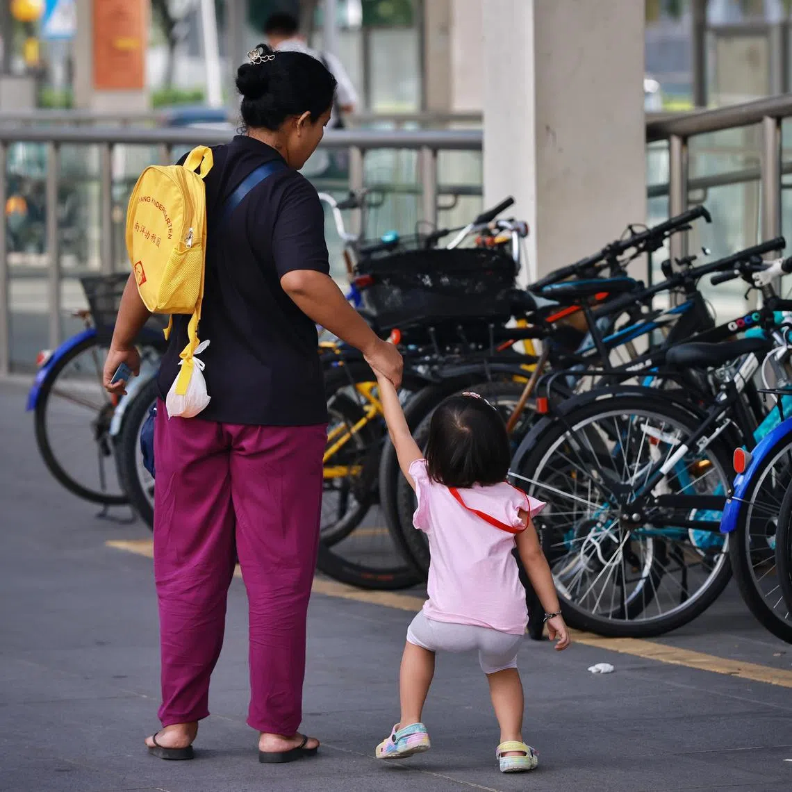 A domestic helper with a child outside Hillion mall on Feb 16, 2023.