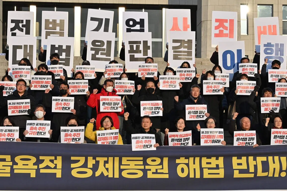 South Korean opposition lawmakers and supporters of the victims of Japan's wartime forced labour hold placards reading, "We oppose the Yoon Seok-yeol government's humiliating solution to the forced labour issue!", during a protest against a public hearing on the issue at the National Assembly in Seoul on Jan 12, 2023. 