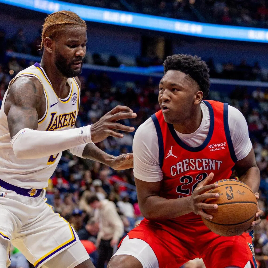 New Orleans Pelicans center Derik Queen dribbles against Los Angeles Lakers center Deandre Ayton during the second half at Smoothie King Center.