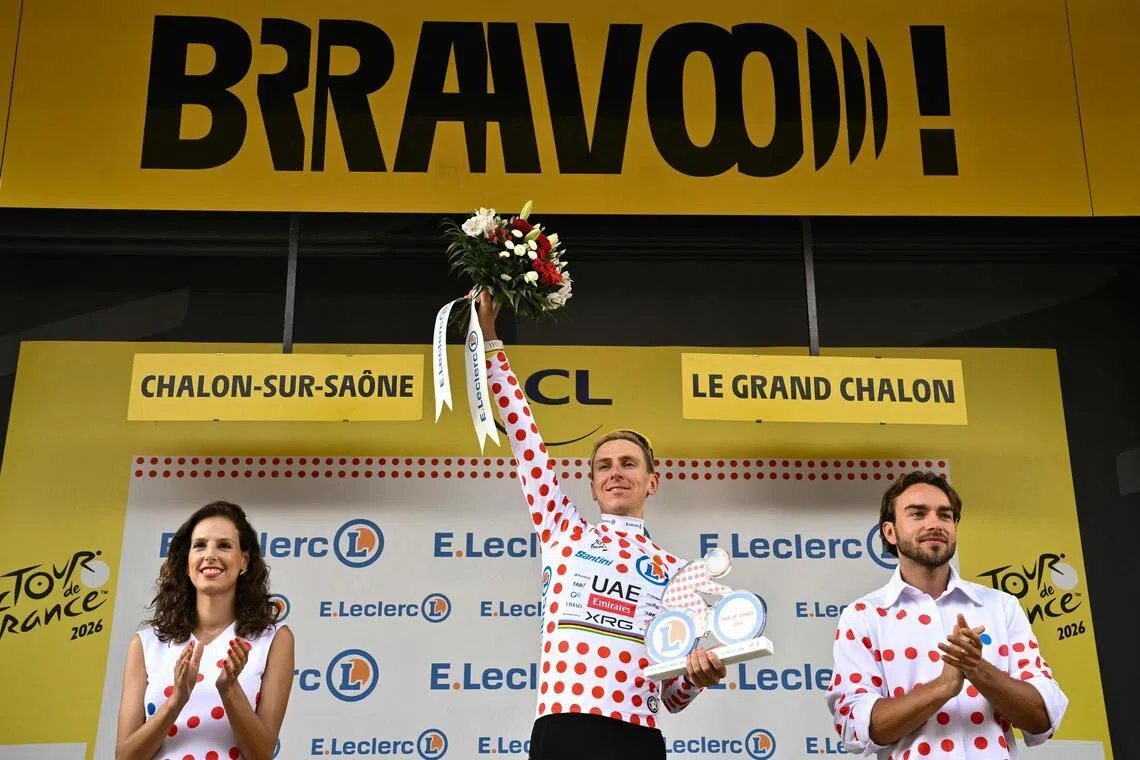 Slovenian rider Tadej Pogacar celebrates on the podium with the best climber’s polka-dot jersey after the 12th stage of the Tour de France.