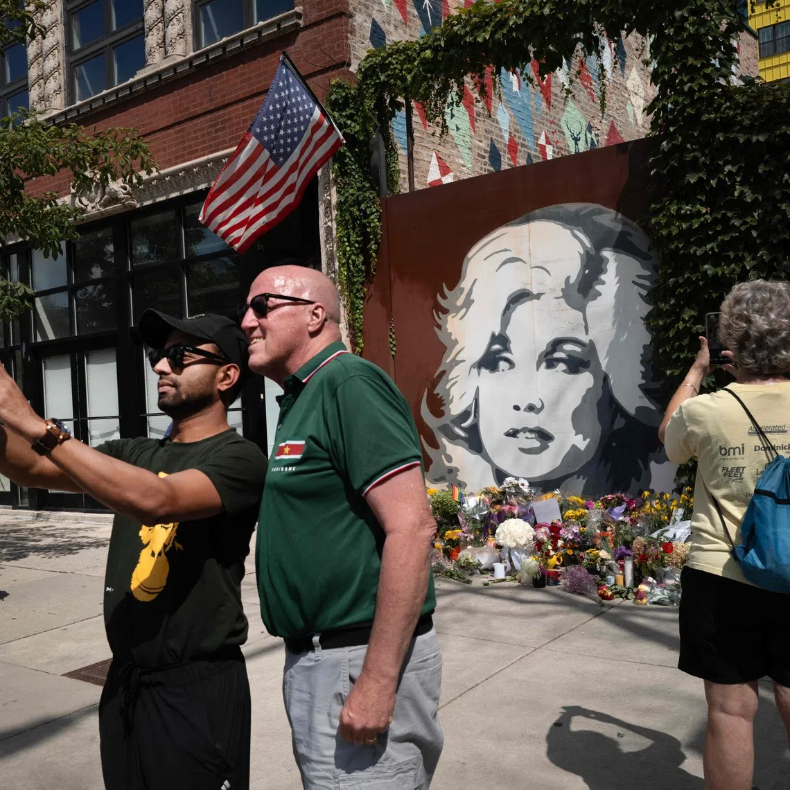 Fans of Dolly Parton visit a mural featuring her likeness in Chicago on Aug 26.