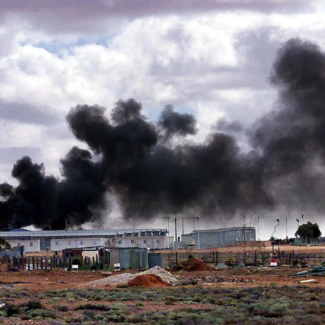 Smoke rises from fires set by angry illegal immigrants being held at the Woomera detention centre in South Australia in the remote outback on Aug 28, 2000. 