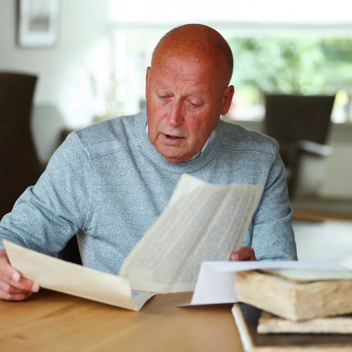 Paul Post, a retired Dutch systems specialist, looks at the war-time diaries of his father, who described working in the Netherlands' diamond bureau during the Nazi occupation, in Driehuis, Netherlands October 6, 2025. REUTERS/Piroschka van de Wouw