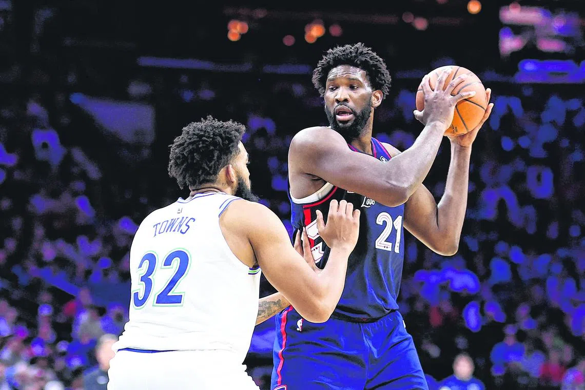 Joel Embiid is guarded by Karl-Anthony Towns during the second quarter at the Wells Fargo Center.
