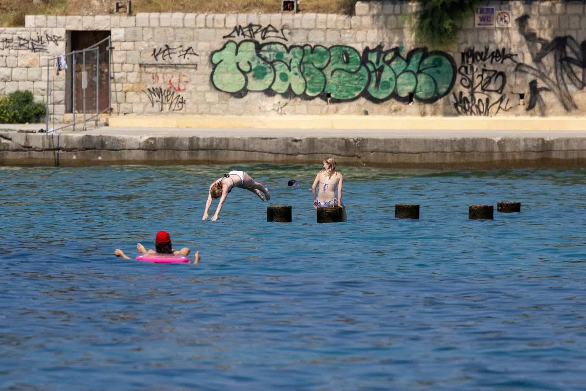 FILE PHOTO: A girl plunges into the Adriatic Sea in Split, Croatia, July 17, 2024. REUTERS/Antonio Bronic/File Photo