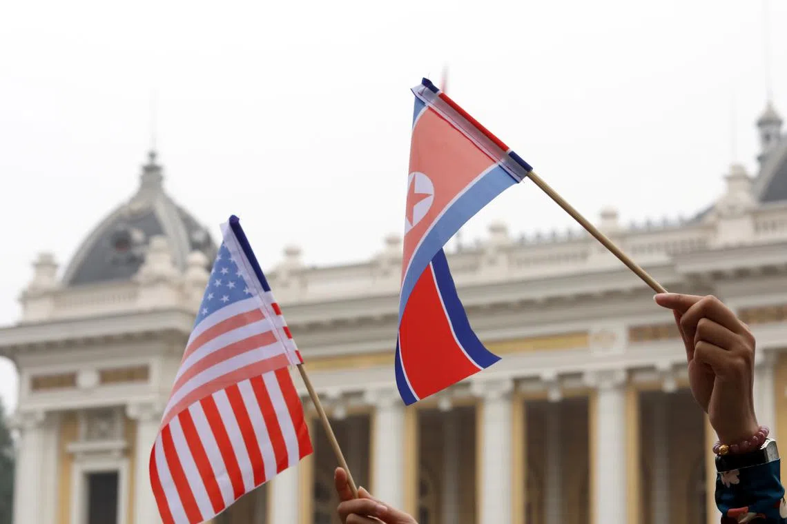 Residents hold US and North Korean flags while they wait for motorcade of North Korea's leader Kim Jong Un en route to the Metropole Hotel for the second US- North Korea summit in Hanoi, Vietnam February 28, 2019. REUTERS/Kham/File Photo