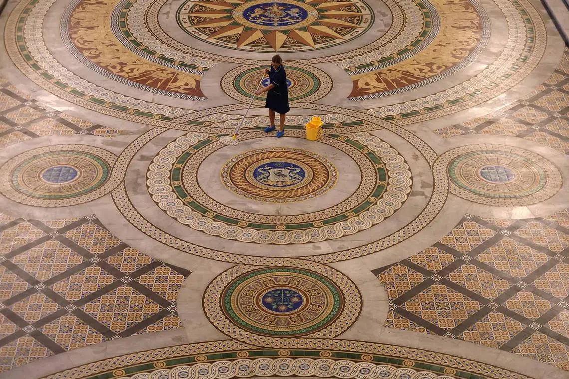 Cleaner Louise Brewis mops the Minton tiled floor of St George's Hall, which is to go on display to the public for the first time since 2019, in Liverpool, Britain, July 31, 2023. 