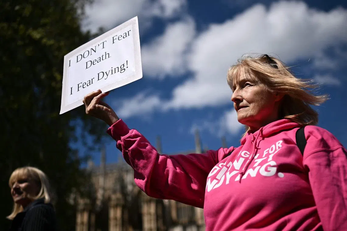 A woman holds a placard during a gathering in favour of legalising assisted suicide, in central London, on April 29.