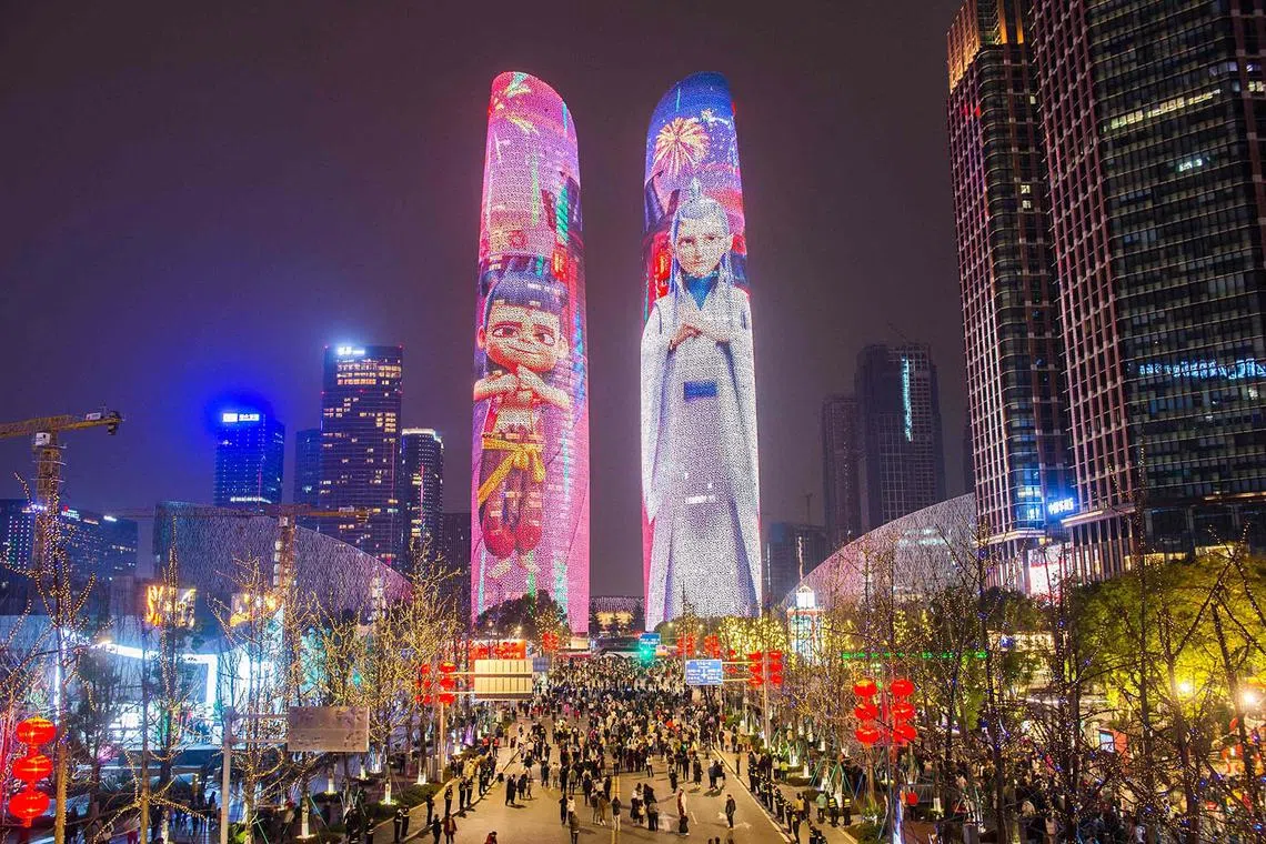 Buildings are lit with characters from the movie Ne Zha 2 in Chengdu, in China’s southwest Sichuan province on Feb 12, 2025. The animated Chinese blockbuster, based on traditional mythology, has smashed multiple box office records on its way to becoming the country's most successful movie ever. 