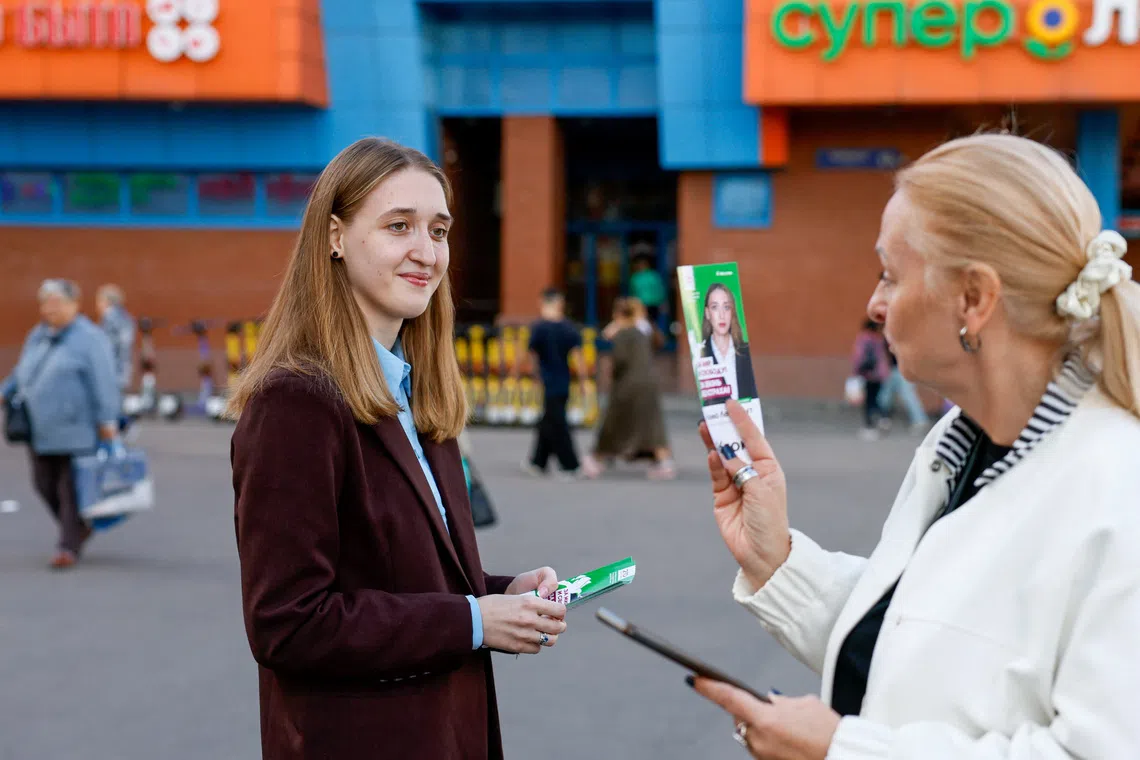 Polina Lermant, 24, a candidate for Russia's liberal Yabloko party running in a single-mandate constituency in the upcoming parliamentary election, hands out flyers to passers-by on a street in Moscow, Russia, September 3, 2026. REUTERS/Yulia Morozova