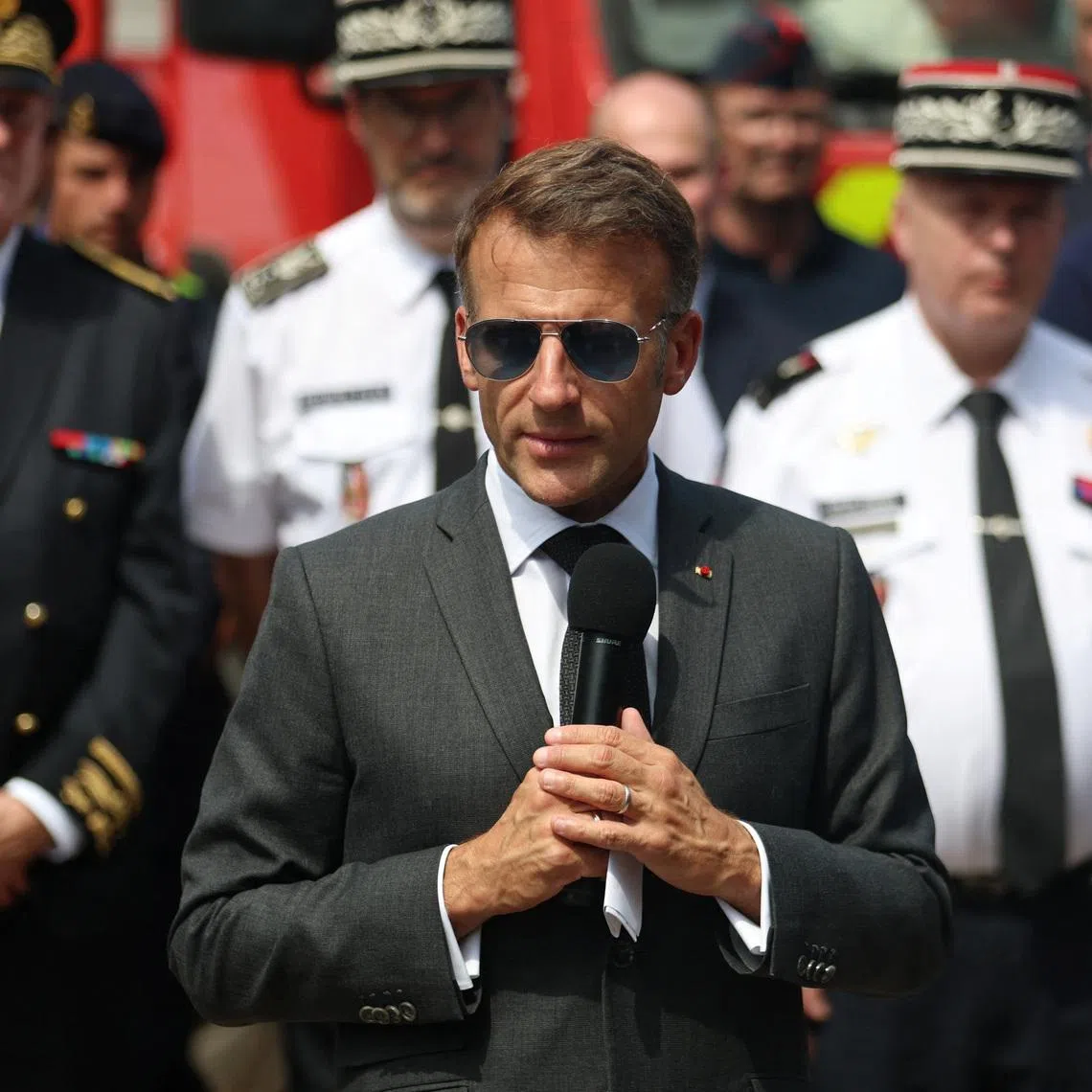 French President Emmanuel Macron speaks as he meets with forest police, police and firefighters following the forest fires in Fontainebleau on July 16.