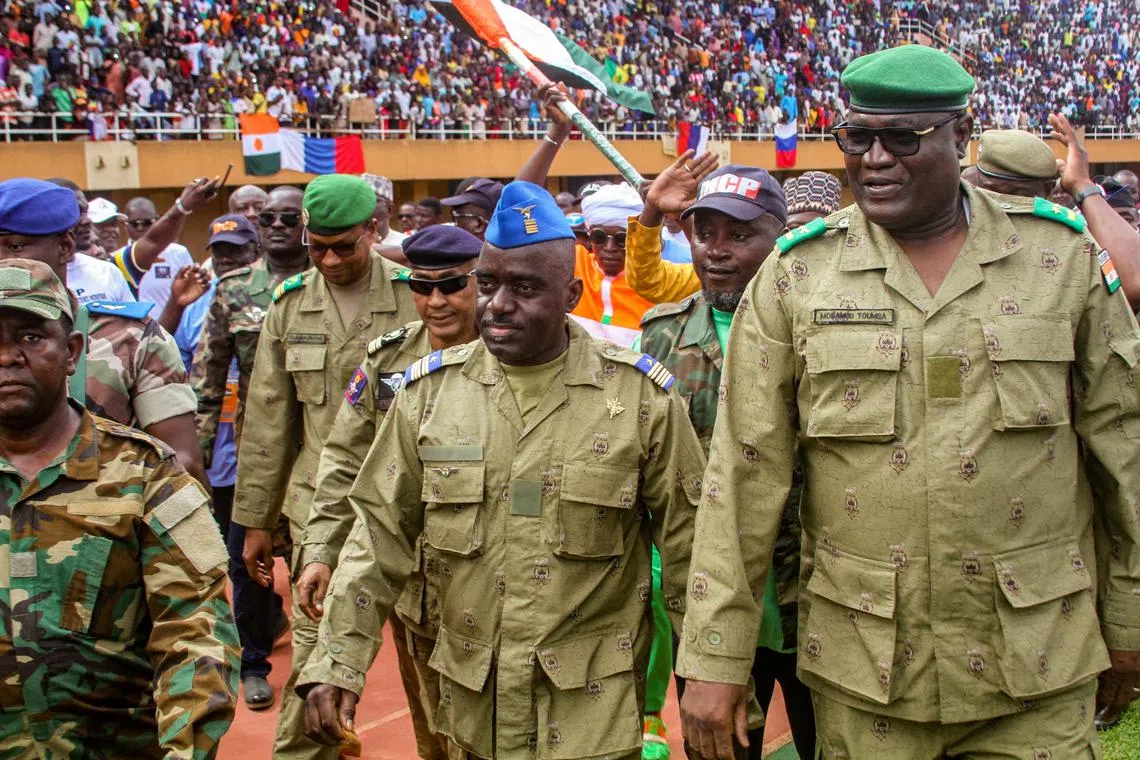 Members of a military council that staged the coup in Niger attend a rally at a stadium in Niamey.