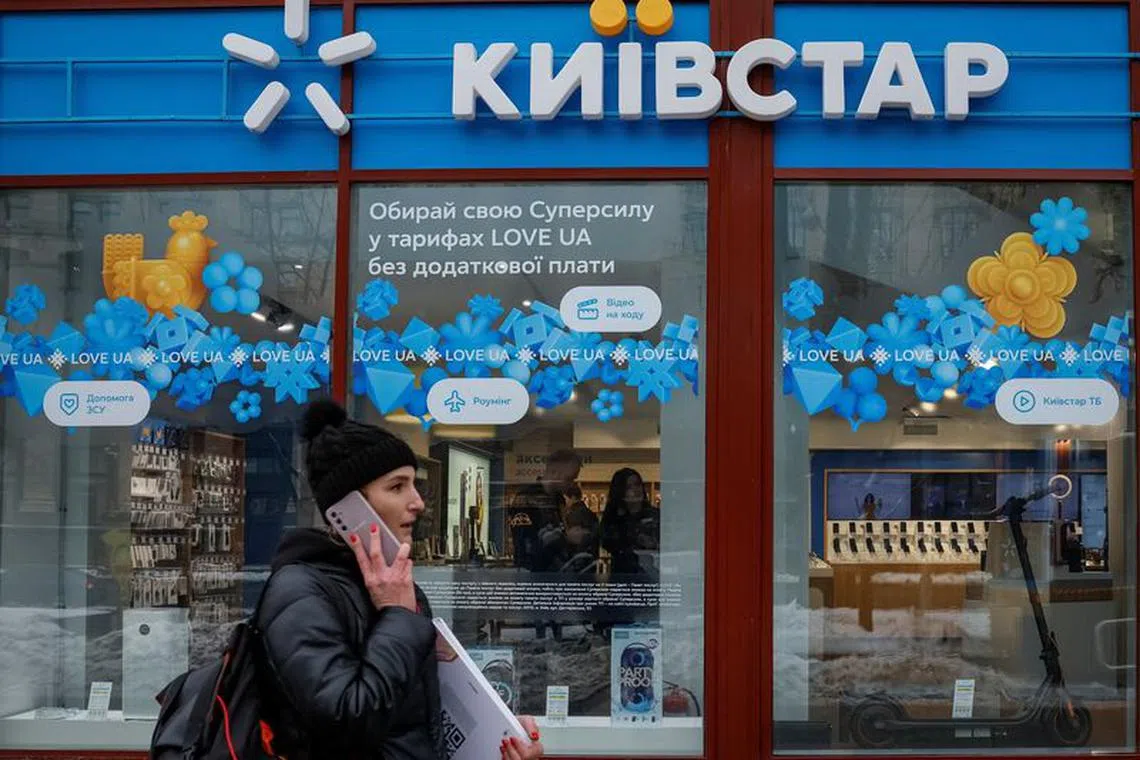 A woman walks past a store of Ukraine's telecommunications company Kyivstar, amid Russia's attack on Ukraine, in Kyiv, Ukraine December 12, 2023. REUTERS/Alina Smutko