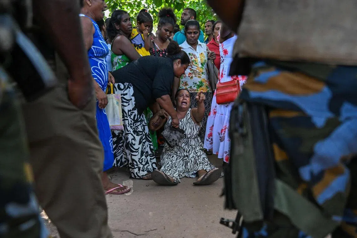 A relative of a victim killed in clashes between inmates of two drug gangs grieves in front of the Negombo prison on the outskirts of Colombo on July 7.