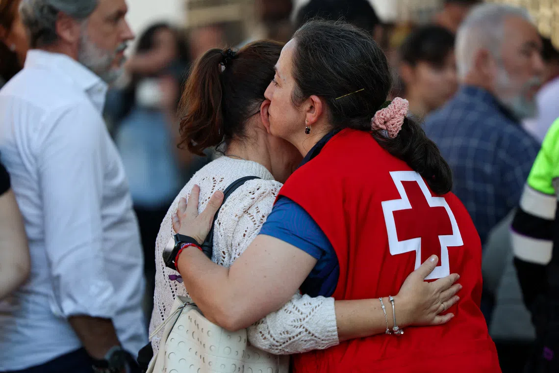 A member of the Spanish Red Cross embraces a relative, as they wait for news at a school, following the collision of two high-speed trains between the towns of Mora and Orgaz, in Urda, Spain on Oct 28.