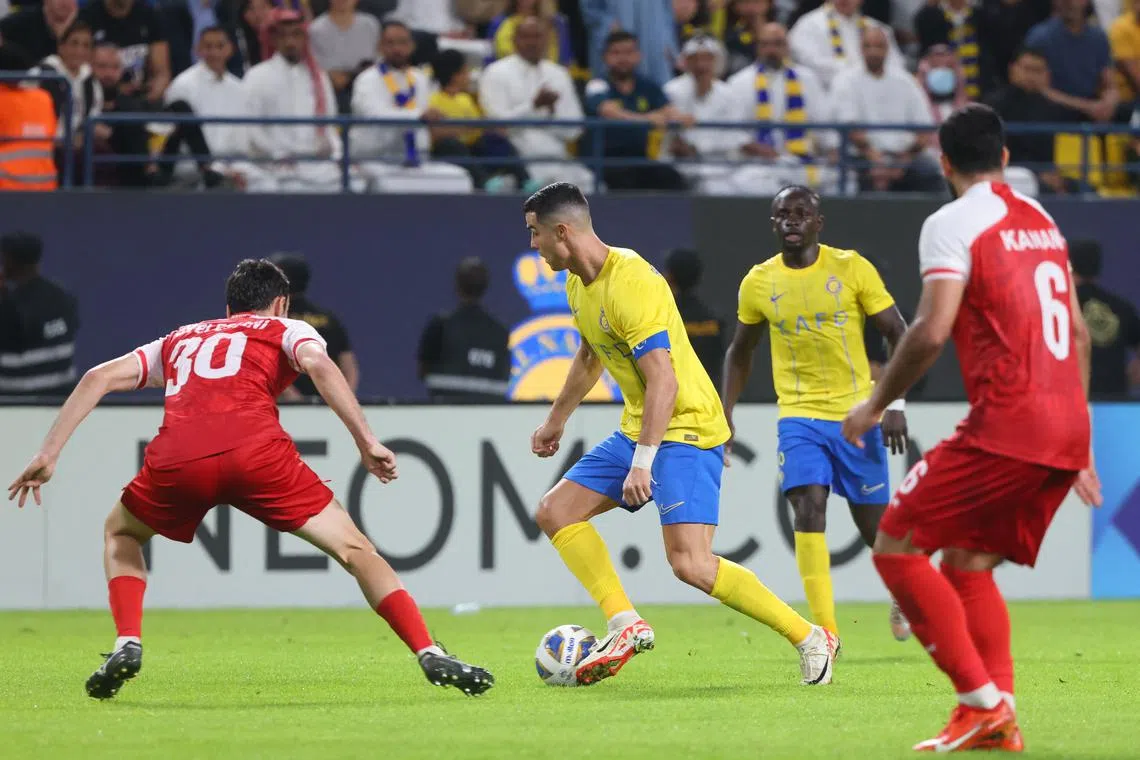 Persepolis' Georgian defender Giorgi Gvelesiani marks Nassr's Portuguese forward Cristiano Ronaldo during the match.