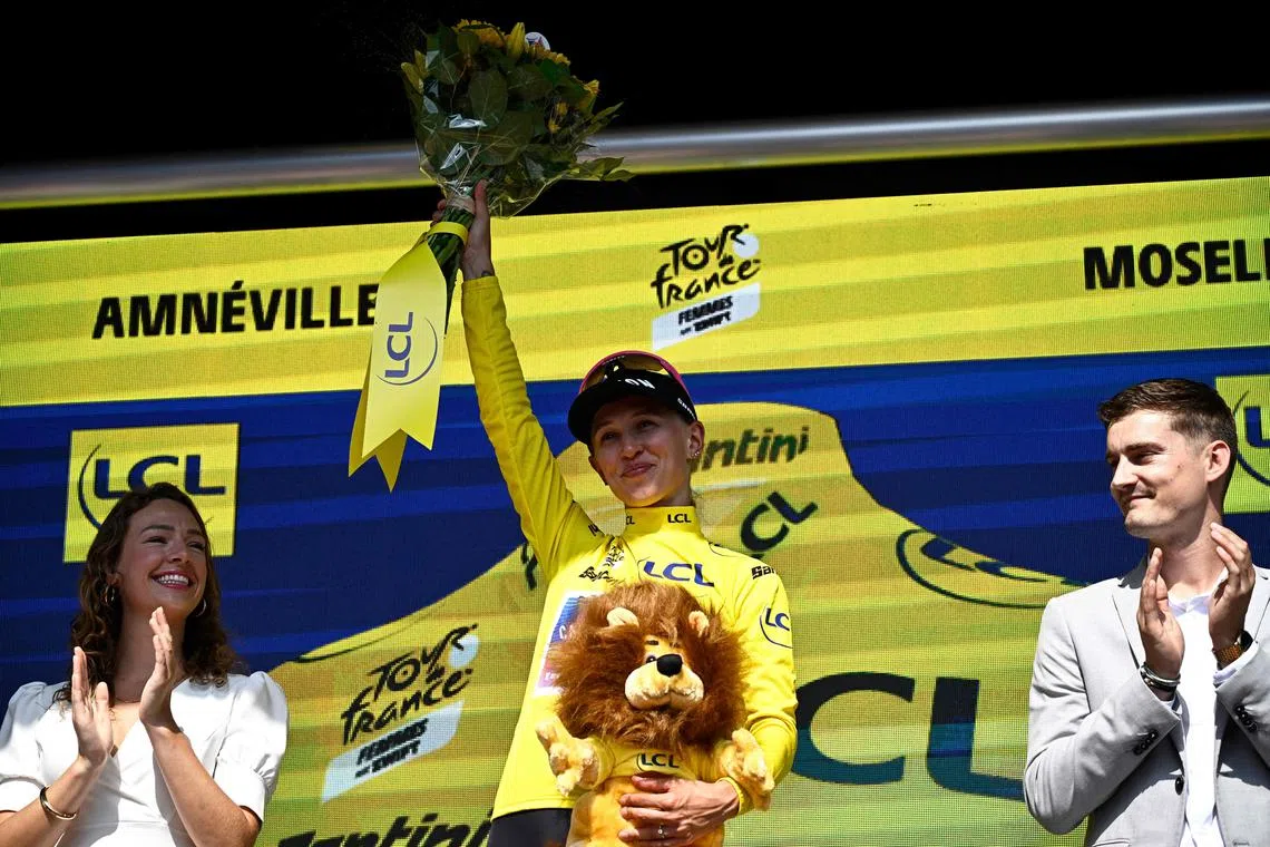 Canyon//SRAM Racing team's Polish rider Katarzyna Niewiadoma celebrates her overall leader yellow jersey on the podium after the 5th stage (out of 8) of the Women's Tour de France, a 152.5 km ride from Bastogne in south-eastern Belgium to Amneville in north-eastern France, on Aug 15, 2024.
