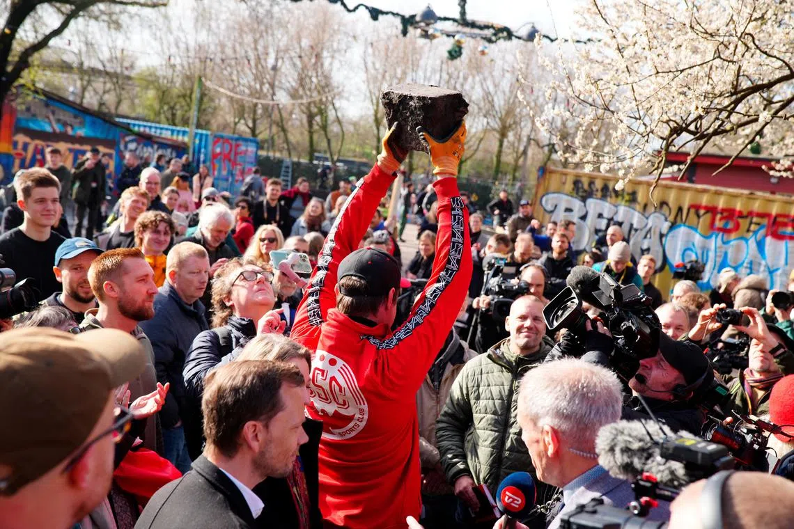 Citizens of the free village Christiania jointly dig up the cobblestones at Pusher Street, in Copenhagen, Denmark, April 6, 2024.  Ritzau Scanpix/via REUTERS