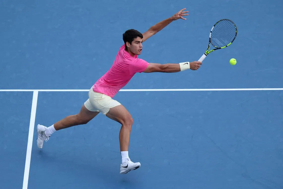 Carlos Alcaraz of Spain playing a backhand volley against Dusan Lajovic of Serbia in their third round match at the Miami Open in Hard Rock Stadium.