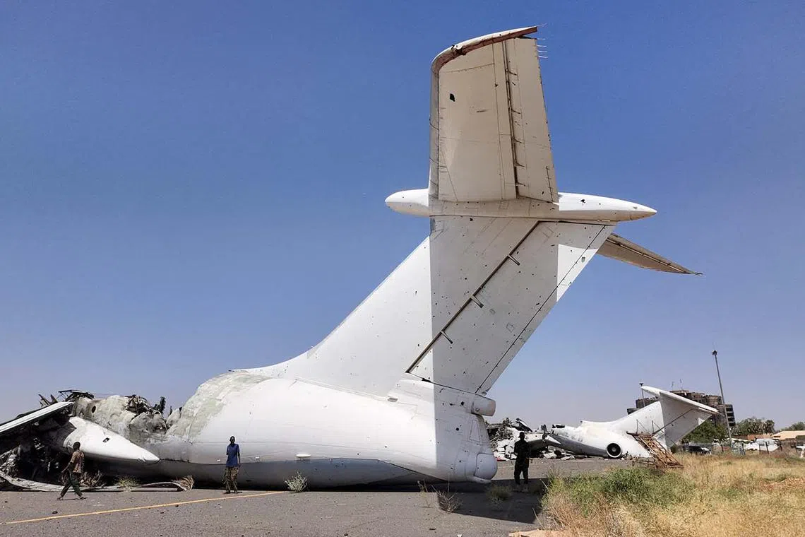 Members of Sudanese army walking next to a destroyed plane's wreckage on the tarmac at Khartoum Airport, after the Sudanese army deepened its control over the capital Khartoum, from the Rapid Support Forces (RSF), in Khartoum, Sudan, March 27, 2025. 