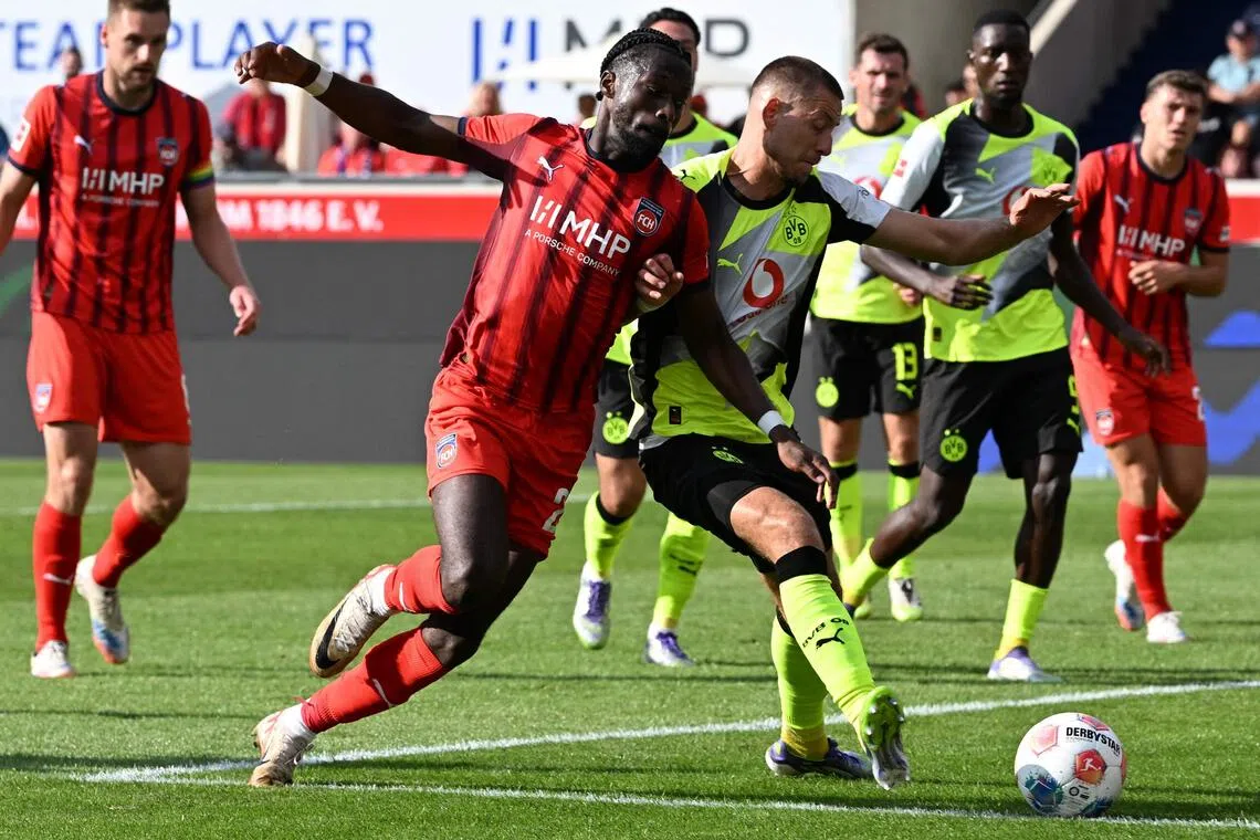 Heidenheim defender Omar Traore and Dortmund defender Waldemar Anton vie for the ball in their Bundesliga football match in Heidenheim on Sept 13, 2025.