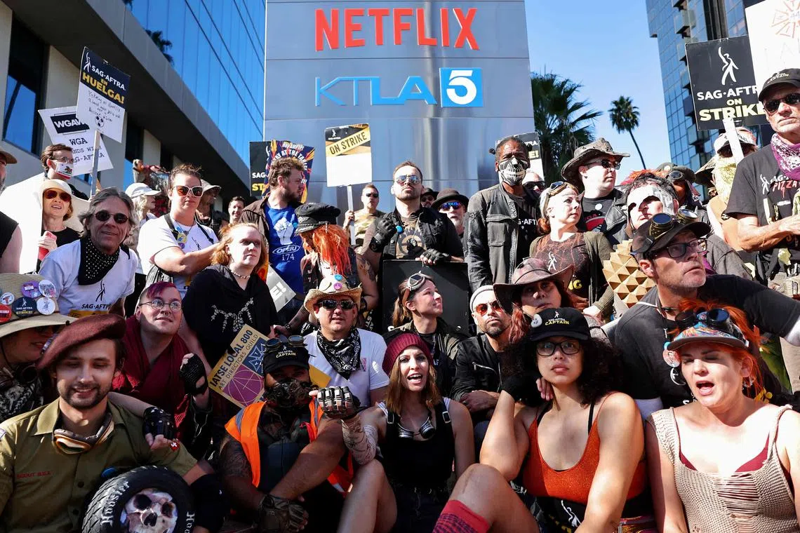 SAG-AFTRA members pose for a group photo, during a "Post Apocalyptic" themed picket outside Netflix's studios.
