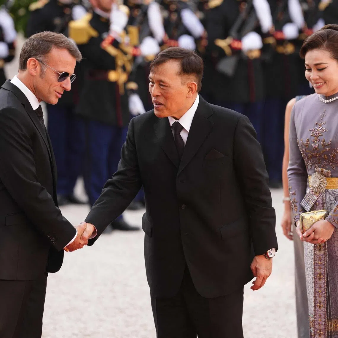 France's President Emmanuel Macron (L) greets Thailand's King Maha Vajiralongkorn (C) and Thailand's Queen Suthida (R) as they arrive at The Elysee Presidential Palace for a working dinner as part of the Thai King's State visit to France, in Paris on June 29, 2026. (Photo by Dimitar DILKOFF / AFP)