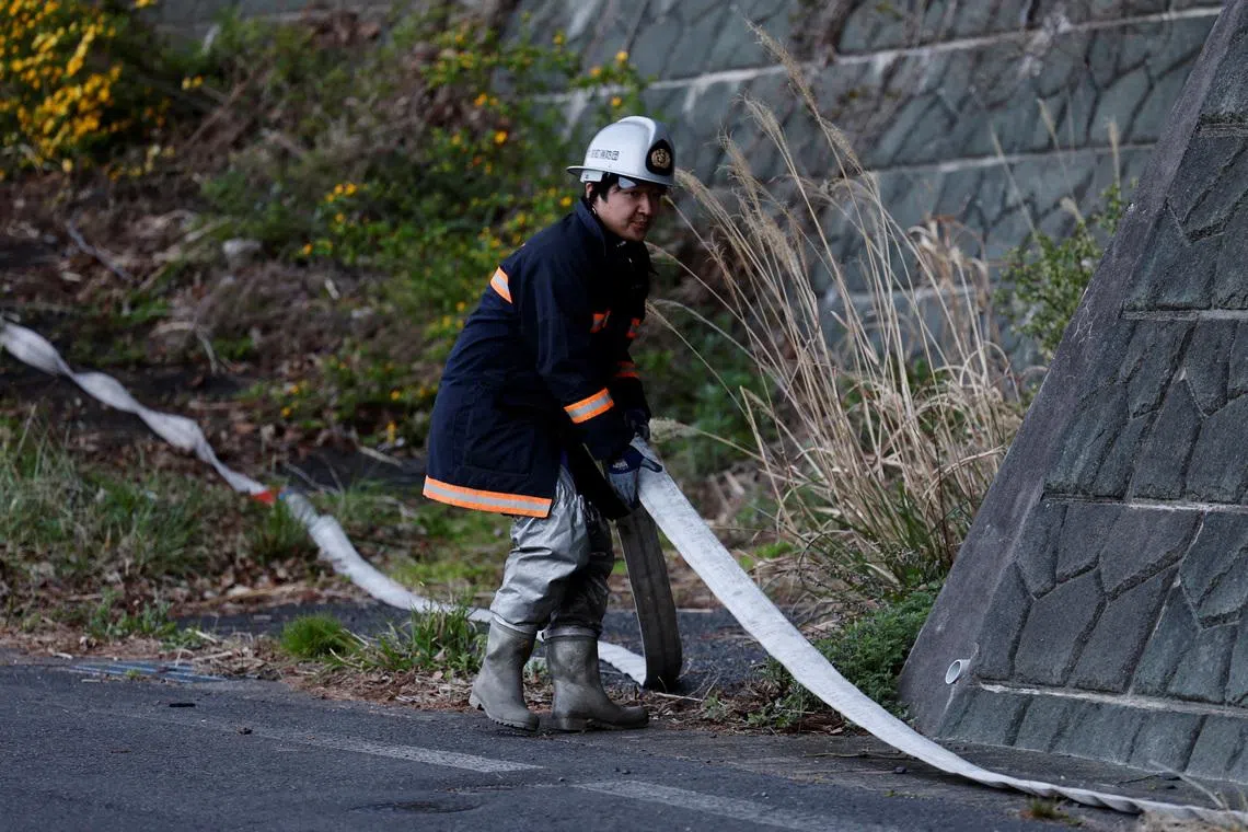 Volunteer firefighter Ryota Haga prepares to connect fire hoses to battle a wildfire in Otsuchi, Iwate Prefecture, Japan, April 26, 2026. REUTERS/Kim Kyung-Hoon