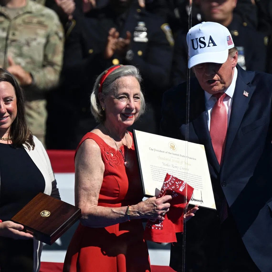 US President Donald Trump presents the Presidential Medal of Freedom to Alison Crowther, on behalf of her son Welles Remy Crowther, a volunteer firefighter who died in the Sept 11, 2001 attacks.