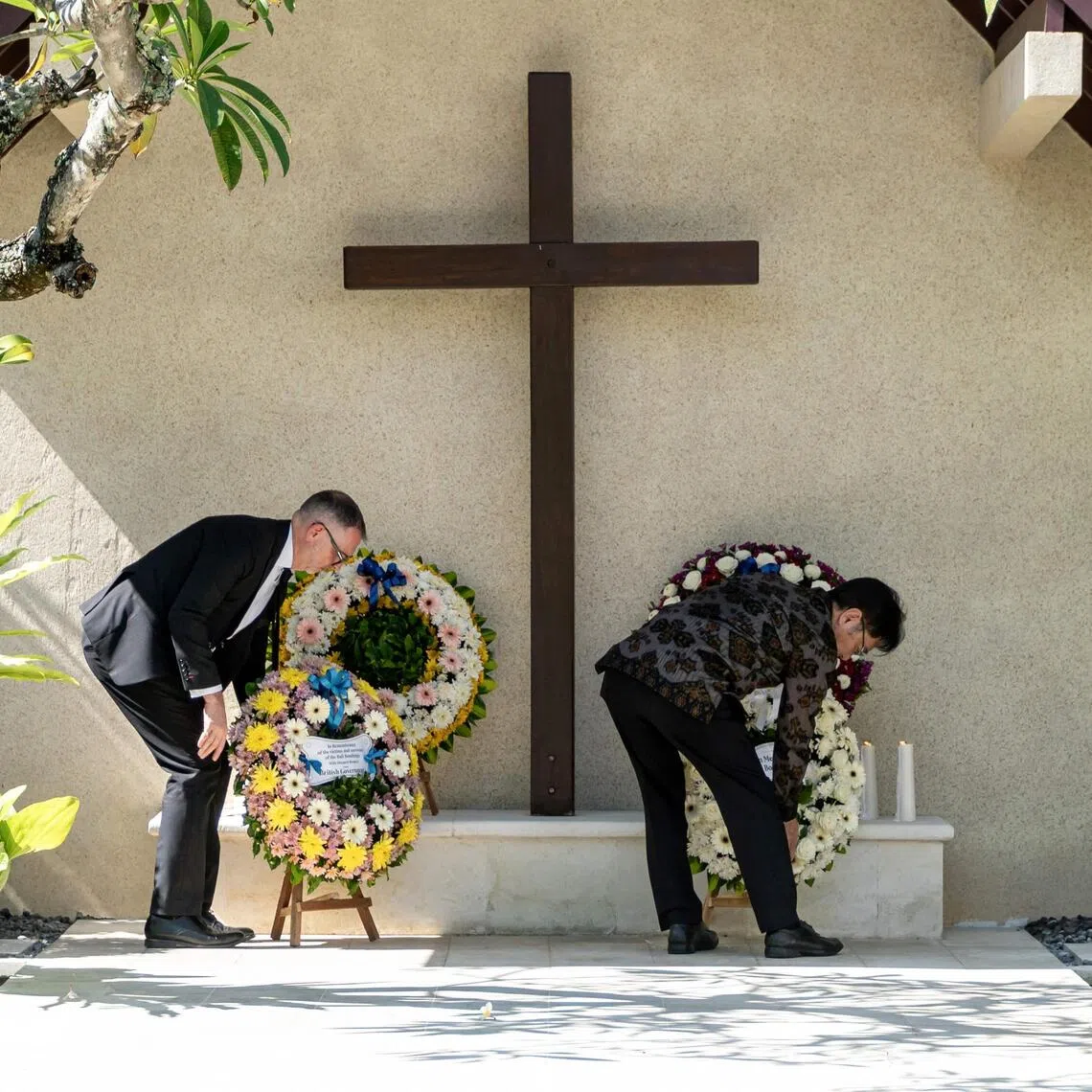 British Consul-General Nigel Greetham (left) and Japanese Consul-General Miyakawa Katsutoshi (right) place wreaths during a memorial service held to mark the 20th anniversary of the 2005 Bali bombings.