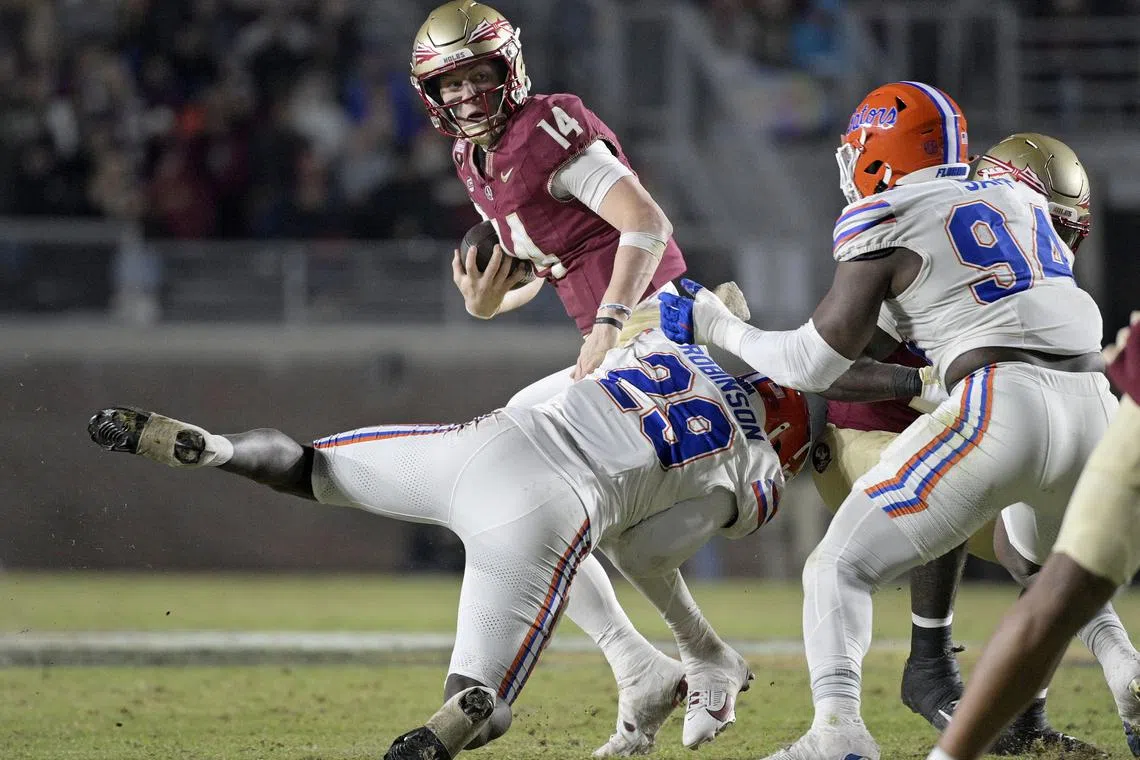 Nov 30, 2024; Tallahassee, Florida, USA; Florida State Seminoles quarterback Luke Kromenhoek (14) is tackled by Florida Gators linebacker Jaden Robinson (29) during the second half at Doak S. Campbell Stadium. Melina Myers-Imagn Images/File Photo