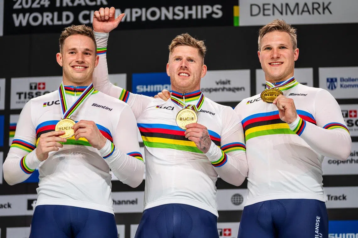 Netherlands' Harrie Lavreysen, Roy van den Berg and Jeffrey Hoogland celebrate on the podium after winning men's team sprint final at the UCI Track Cycling World Championships in Ballerup, Denmark, on Oct 16.