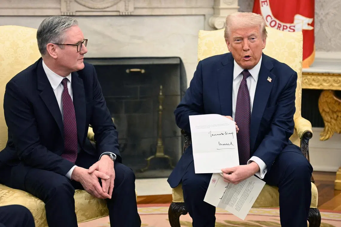 US President Donald Trump holds a letter from Britain's King Charles III during a bilateral meeting with British Prime Minister Keir Starmer in the Oval Office of the White House in Washington, DC, on February 27, 2025. Starmer is meeting Trump to plead for a US backstop to any Ukraine ceasefire, insisting it would be the only way to stop Russia's Vladimir Putin from invading again. Starmer arrived in Washington late Wednesday to build on a visit by French President Emmanuel Macron, amid growing concerns in Europe that the US leader is about to sell Kyiv short in negotiations with Putin. (Photo by Jim WATSON / AFP)