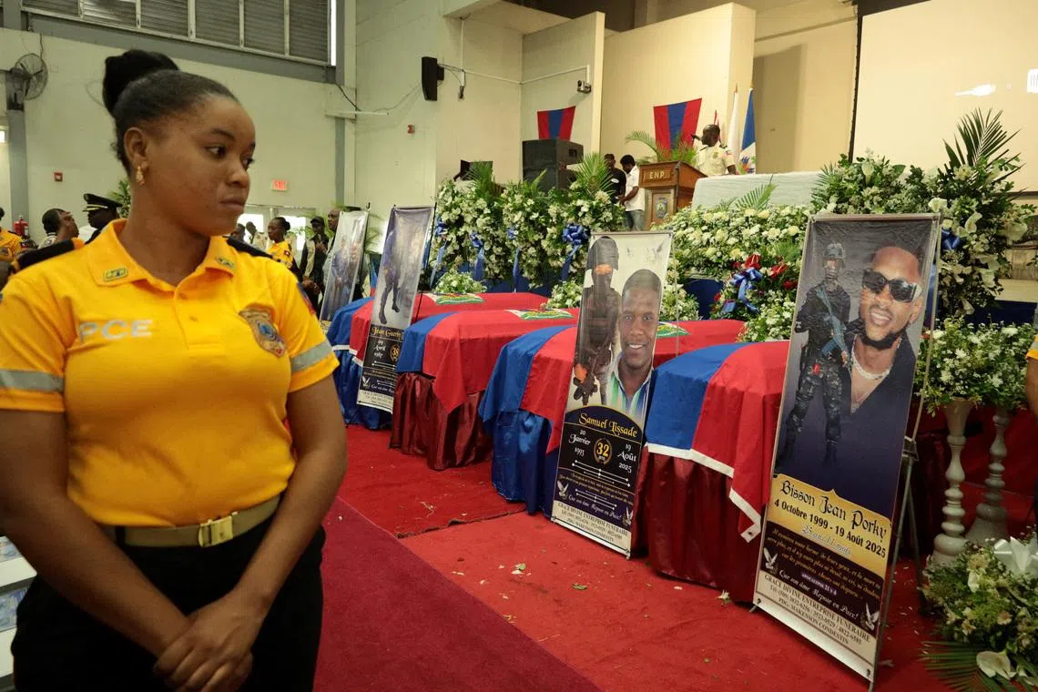 FILE PHOTO: A member of the police attends the funeral of four Haitian police officers, two of whom were killed when an explosive drone accidentally detonated at a SWAT base in August, on the outskirts of Port-au-Prince, in Kenscoff, Haiti, September 6, 2025. REUTERS/Egeder Pq Fildor/File Photo
