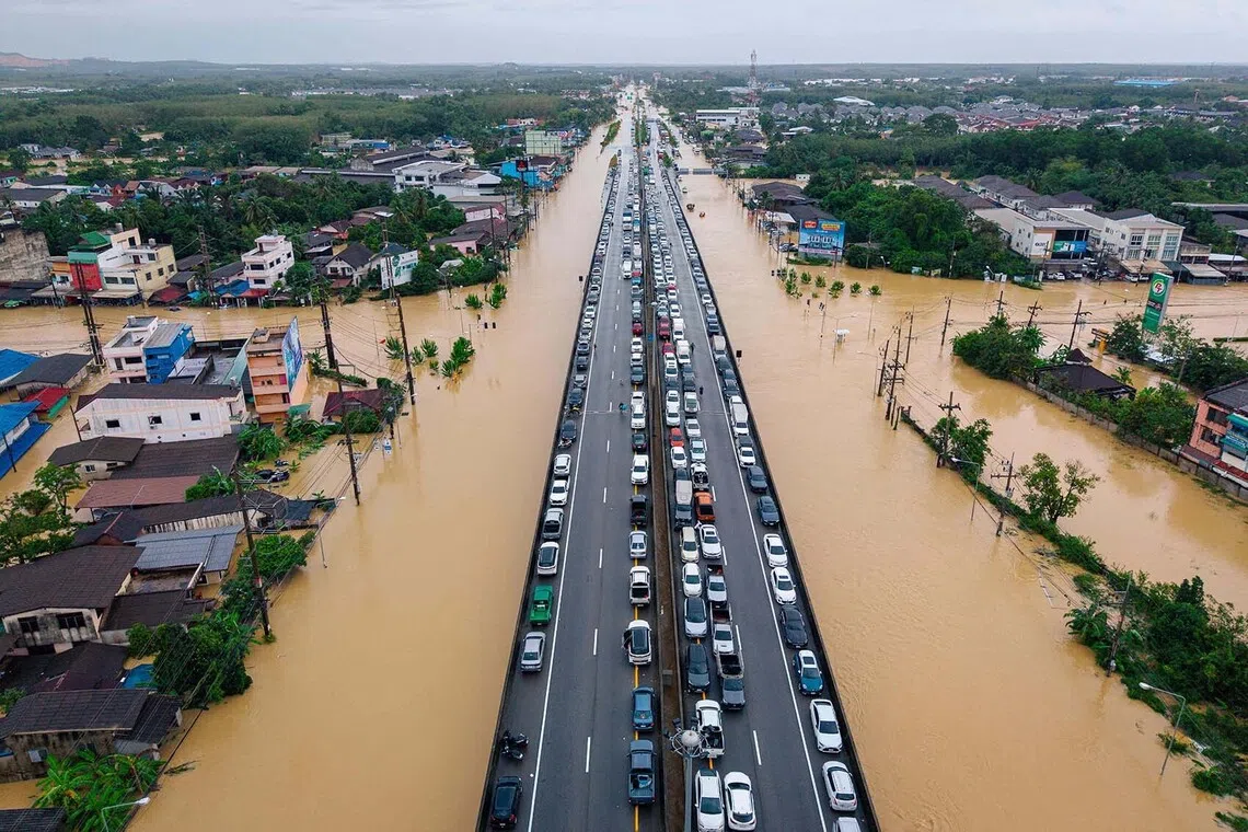 Vehicles parked on an elevated road to keep them out of flood waters in Hat Yai in Thailand's southern Songkhla province, as severe flooding affected thousands of people in the country's south following days of heavy rain, Nov 25, 2025.