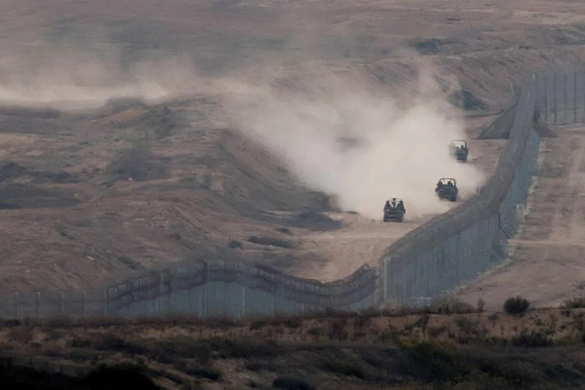 FILE PHOTO: Military vehicles manoeuvre next to a fence, as seen from the Israeli side of the border with Gaza, November 5, 2023. REUTERS/Ronen Zvulun   REFILE - QUALITY REPEAT/File Photo