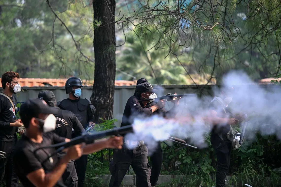 Policemen fire tear gas shells to disperse supporters of jailed former prime minister Imran Khan's Pakistan Tehreek-e-Insaf (PTI) party during a protest in Islamabad on October 5, 2024. Pakistan's capital was locked down on October 5, swarmed by security forces with mobile internet cut as supporters of jailed ex-prime minister Imran Khan attempted to seize the streets in protest. (Photo by FAROOQ NAEEM / AFP)