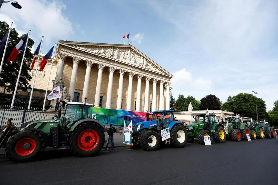 FILE PHOTO: Tractors are parked in front of the French parliament, the Assemblee Nationale, as French farmers gather for a protest to call on lawmakers to adopt a bill that would loosen restrictions on pesticide and water use in farming, in Paris, France May 26, 2025. REUTERS/Abdul Saboor/File Photo