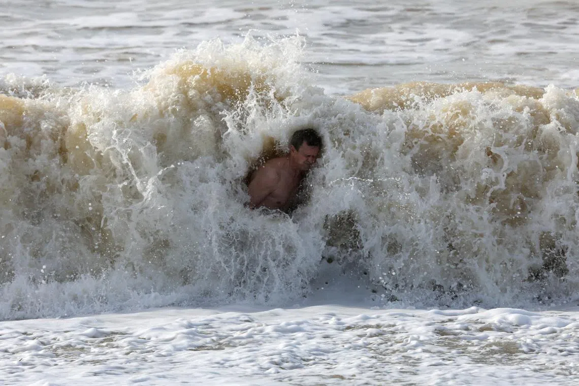 A believer dips into a wave during a ceremony marking the Orthodox Christian feast of Epiphany in the Black Sea resort city of Saky (Saki), Crimea, Jan 19, 2023. 