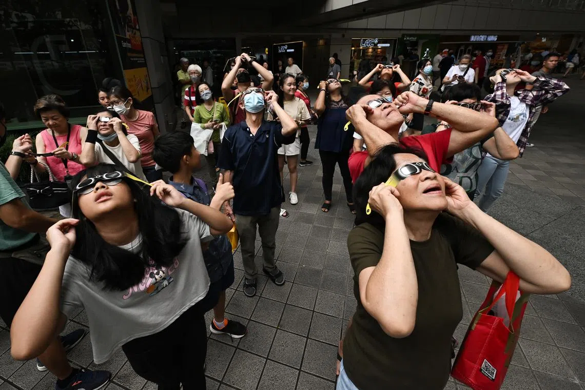 The public and Singapore Sidewalk Astronomy members trying to look for the solar eclipse at Toa Payoh Hub on April 20, 2023.