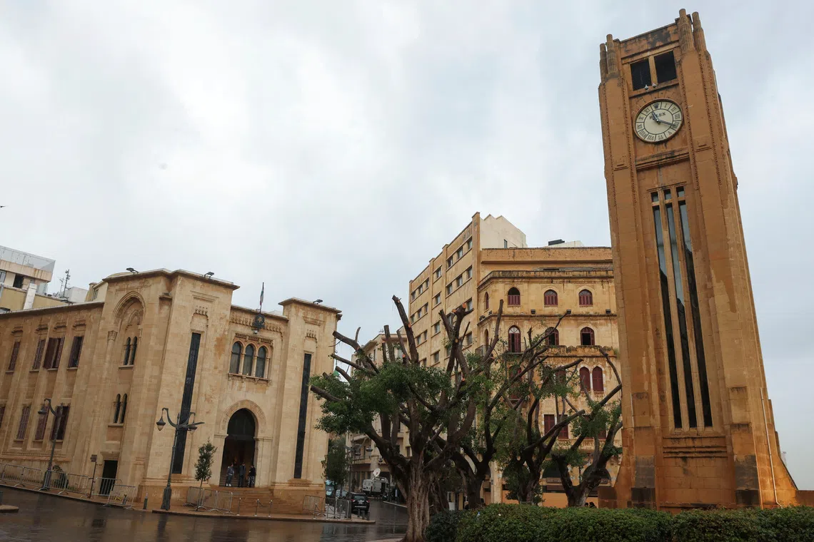 A view of several historic buildings, including a clock tower, on a cloudy day.