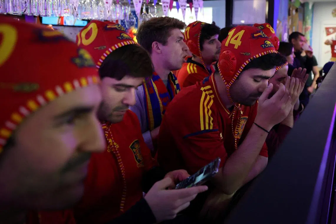 Spanish supporters react as they watch the   Morocco and Spain in a bar in Madrid on Tuesday. 