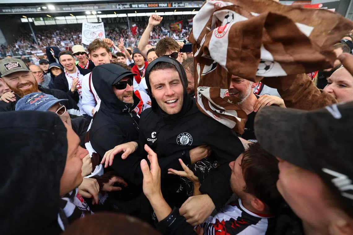 St Pauli coach Fabian Hurzeler celebrating with fans after winning Germany's 2. Bundesliga title at Wehen Wiesbaden's Brita-Arena on May 19, 2024.