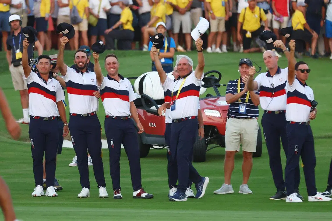 Team USA players wave their hats to celebrate Patrick Cantlay holing a birdie putt on the 18th green during the fourballs.