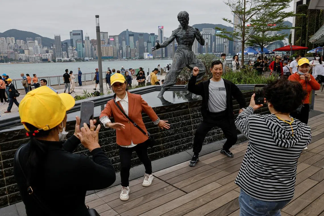 Chinese tourists posing for photos in front of a statue of the martial artist and actor Bruce Lee, on the Avenue of Stars attraction near the Tsim Sha Tsui waterfront on April 26. 