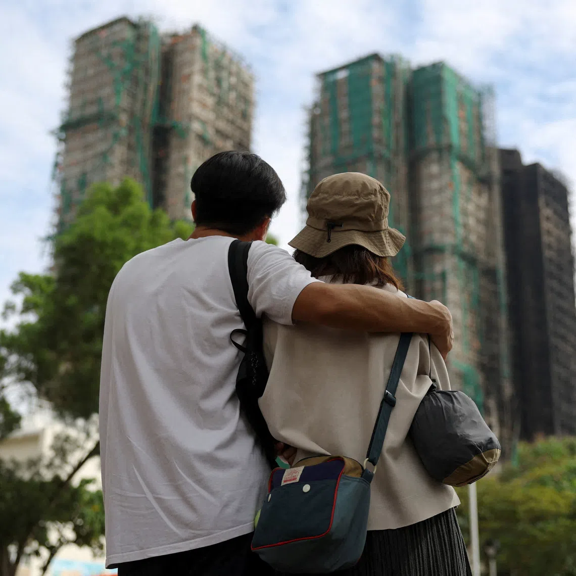 People look on near the Wang Fuk Court housing complex following the deadly fire.